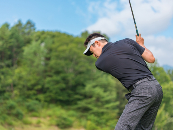 ゴルフでスイングしている男性の画像
